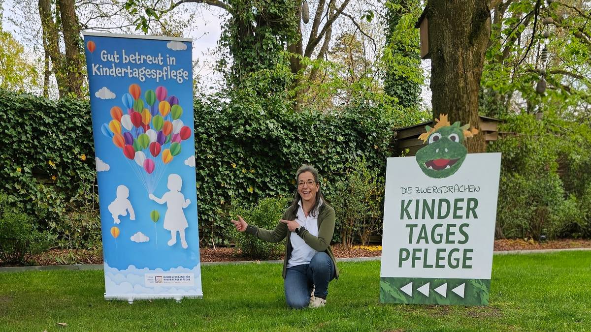 Bärbel Zisenis, qualifizierte Tagesmutter vor dem Eingang der Kindertagespflege Die Zwergdrachen in Celle mit Werbebanner und Standortschild